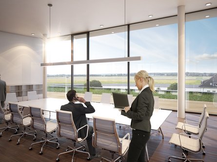 Moderne Konferenzraum mit großem Tisch, mehreren Stühlen und Panoramafenstern mit Blick auf eine grüne Landschaft.